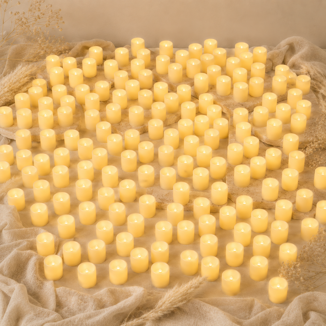 Hundred of small yellow candles on a textured beige surface