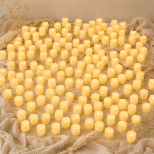 Hundred of small yellow candles on a textured beige surface